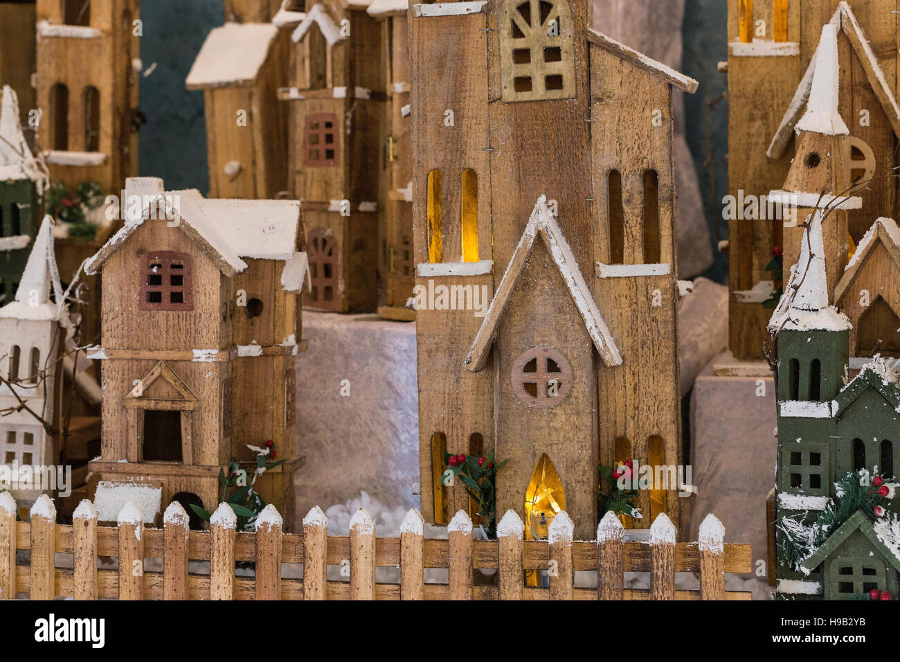 Il villaggio di legno in scena con la recinzione, case e accesa windows, spolverato di neve Foto Stock