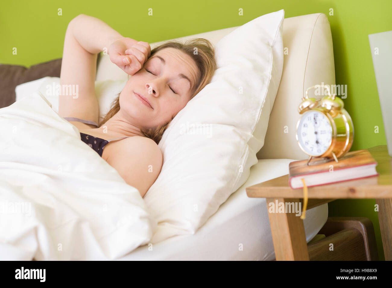 Giovane donna nel letto, dopo il risveglio Foto Stock