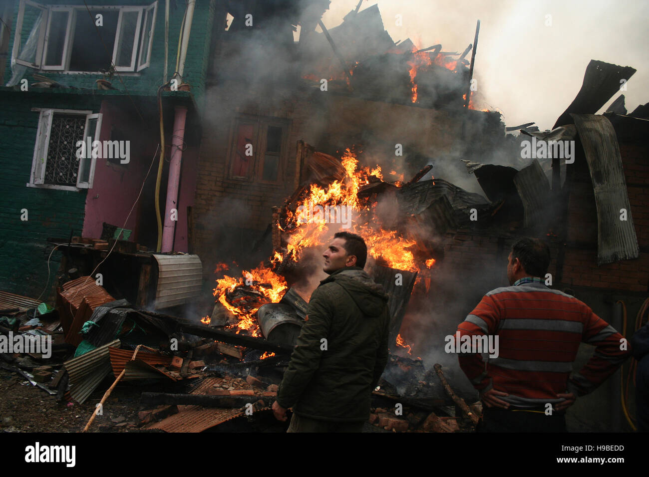 Srinagar, Indiano Kashmir amministrato21. Novembre.popolo del Kashmir guardando il fuoco durante ,una massiccia fire inghiottito decine di case nella zona residenziale di Buchwara Dalgate. Gara di fuoco sono stati rapidi a spegnere le fiamme. Il fuoco ha iniziato da una delle case e diffondersi ad altri. Una bombola di gas blast è detto di avere causato la massiccia fire Credito: Sofi Suhail/Alamy Live News Foto Stock