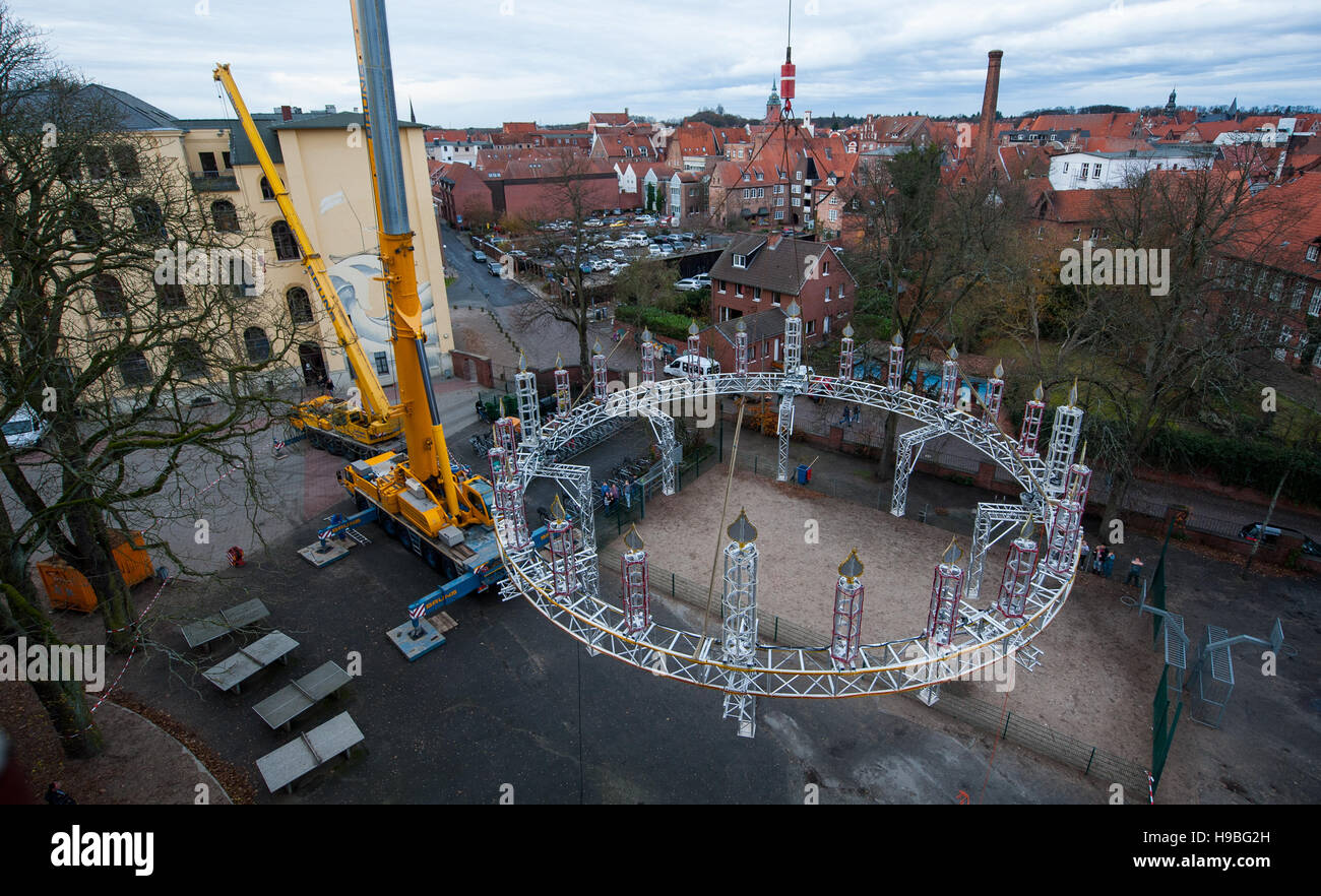 Lueneburg, Germania. Xxi Nov, 2016. Una gru solleva il Wichern corona di Avvento sulla 56-metro-alta torre di acqua in Lueneburg, Germania, 21 novembre 2016. Con un diametro di 13 metri, la corona in alluminio è uno dei più grandi ghirlande in Europa. Con un messaggio di testo o una chiamata telefonica, l'anello può essere illuminata con il bianco e il rosso si illumina per una buona causa. Foto: PHILIPP SCHULZE/dpa/Alamy Live News Foto Stock