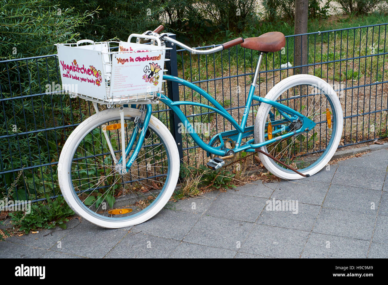 Una bicicletta verde pubblicità un Yogakitchen locale a Dusseldorf, Germania Foto Stock