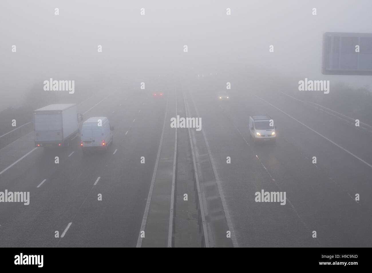 Veicoli sulla M3 vicino alla giunzione con il M25 in una nebbiosa mattina in Surrey Foto Stock