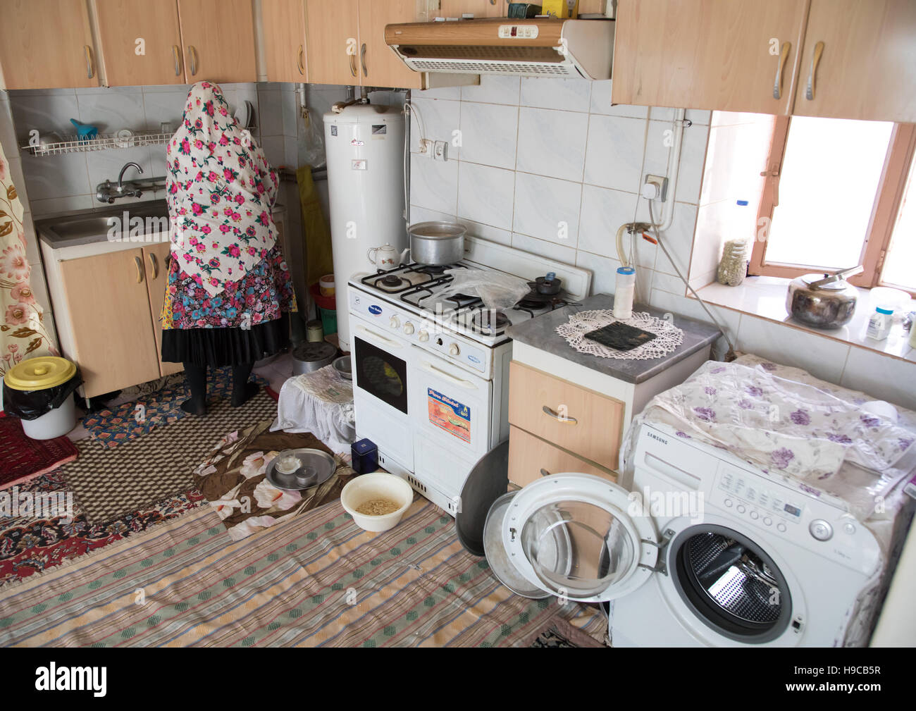 Donna iraniana indossando il tradizionale floreal chador nella sua cucina, Natanz county, Abyaneh, Iran Foto Stock