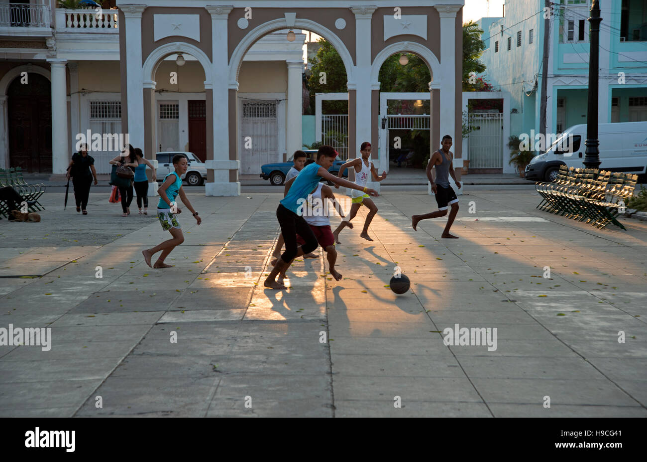 Sagome di adolescenti cubani giocando a calcio per strada come il sole tramonta dietro di loro a Cienfuegos Cuba Foto Stock