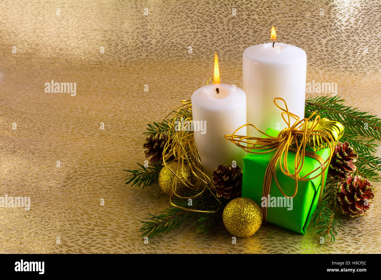 Luce bianca Natale candele, verde confezione regalo, palline dorate, rami  di abete e coni su fondo oro, orizzontale, spazio di copia Foto stock -  Alamy