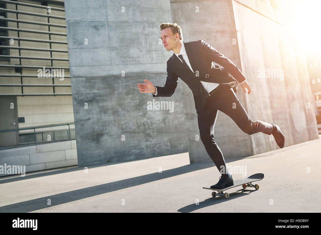 Imprenditore assume un giro su skateboard. All'aperto orizzontale shot Foto Stock