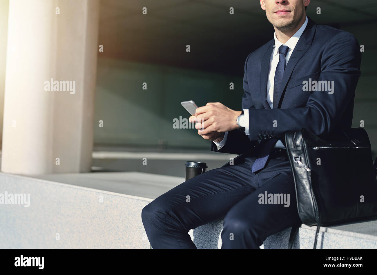 L'uomo con il grigio telefono cellulare nelle sue mani. All'aperto orizzontale shot Foto Stock