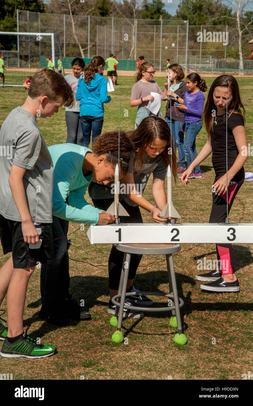 Multirazziale Mission Viejo, CA, middle school gli studenti a prepararsi per il lancio di una polvere nera di razzi come parte del loro programma di studi scientifici. Nota numerata rotaie di lancio. Foto Stock