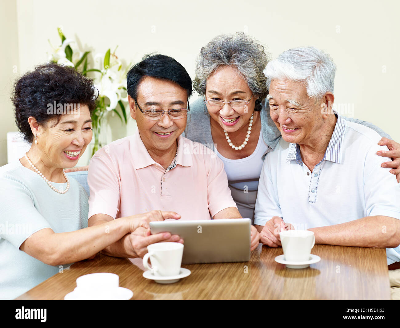 Due senior asian giovane guardando il computer tablet, felice e sorridente Foto Stock