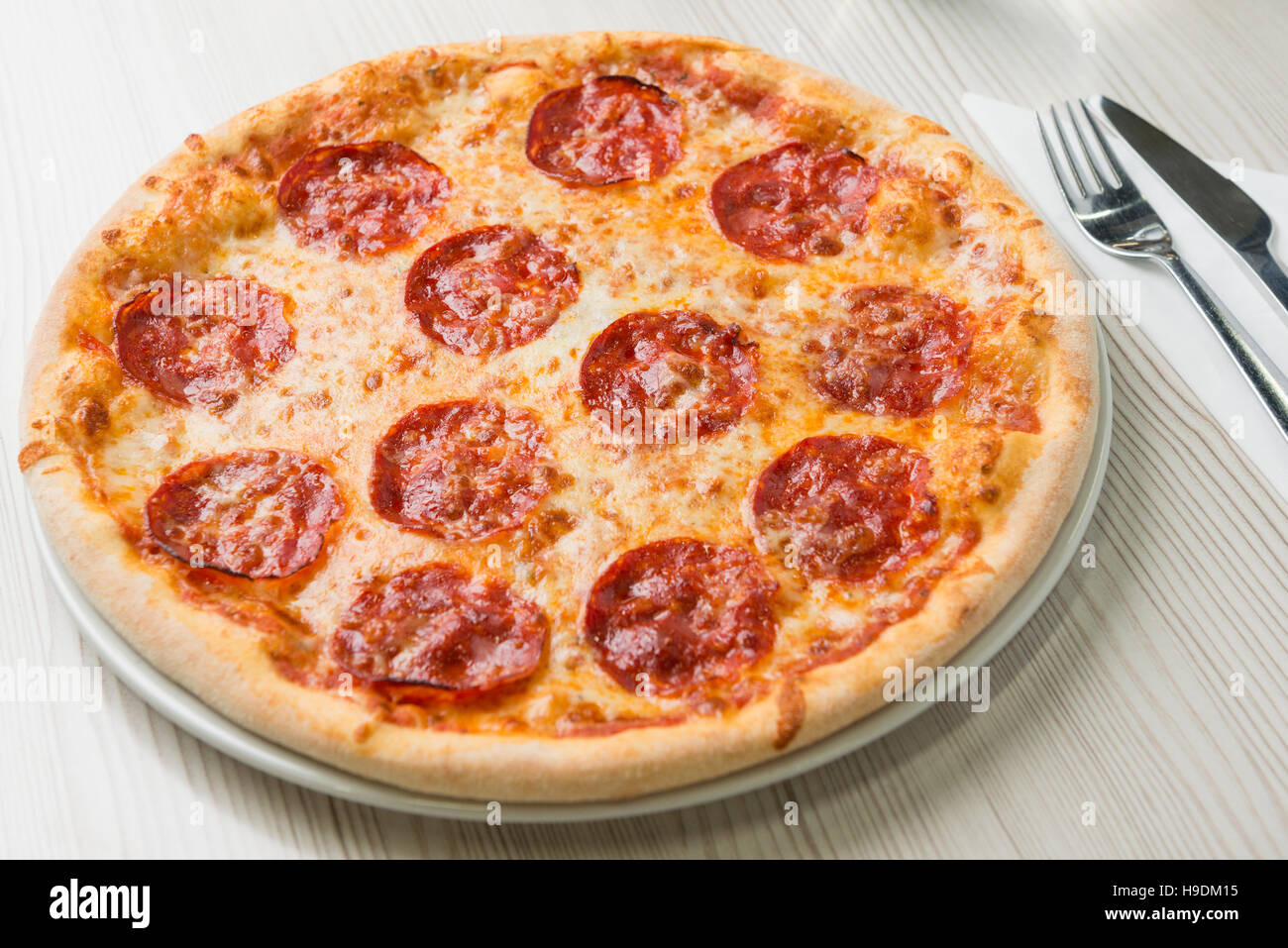Salame pizza sul tavolo Foto Stock