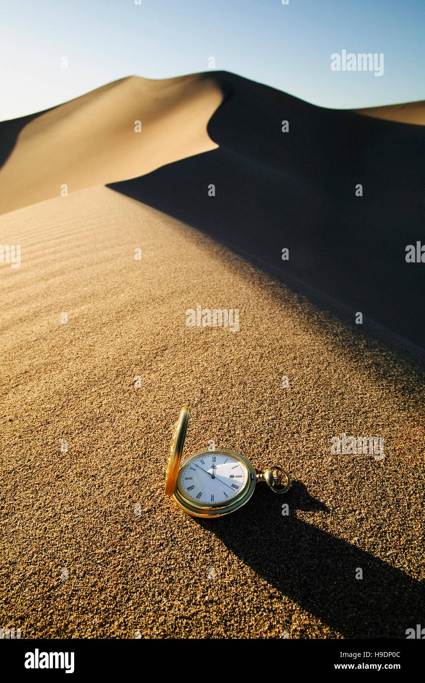 Orologio da tasca in appoggio sulla duna di sabbia Foto Stock