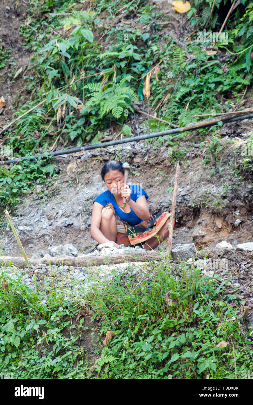 Una donna divisione rocce vicino ortografia in Sikkim, India. Foto Stock