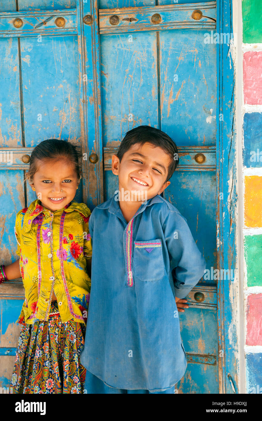 Bambini meghawal davanti alla sua famiglia di mattoni di fango capanna in hodka, un semi-arida regione confinante con la grande raan di kutch Foto Stock