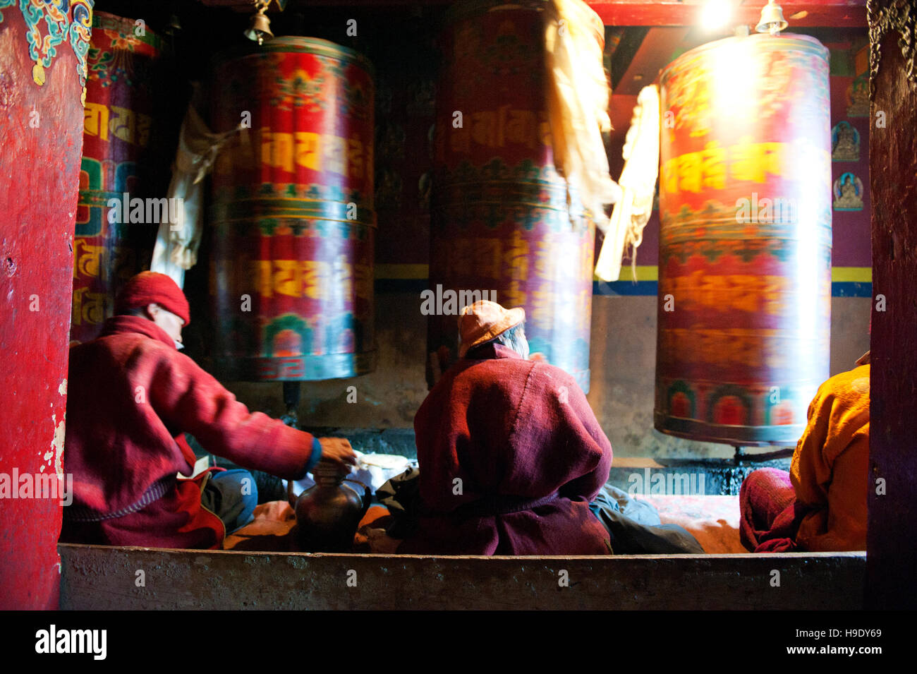 I monaci al monastero di Tawang spin grandi ruote della preghiera mentre canti preghiere buddista nella remota valle di Tawang, India. Foto Stock