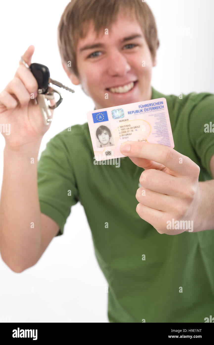 Giovane uomo in possesso di una chiave auto e patente di guida Foto Stock