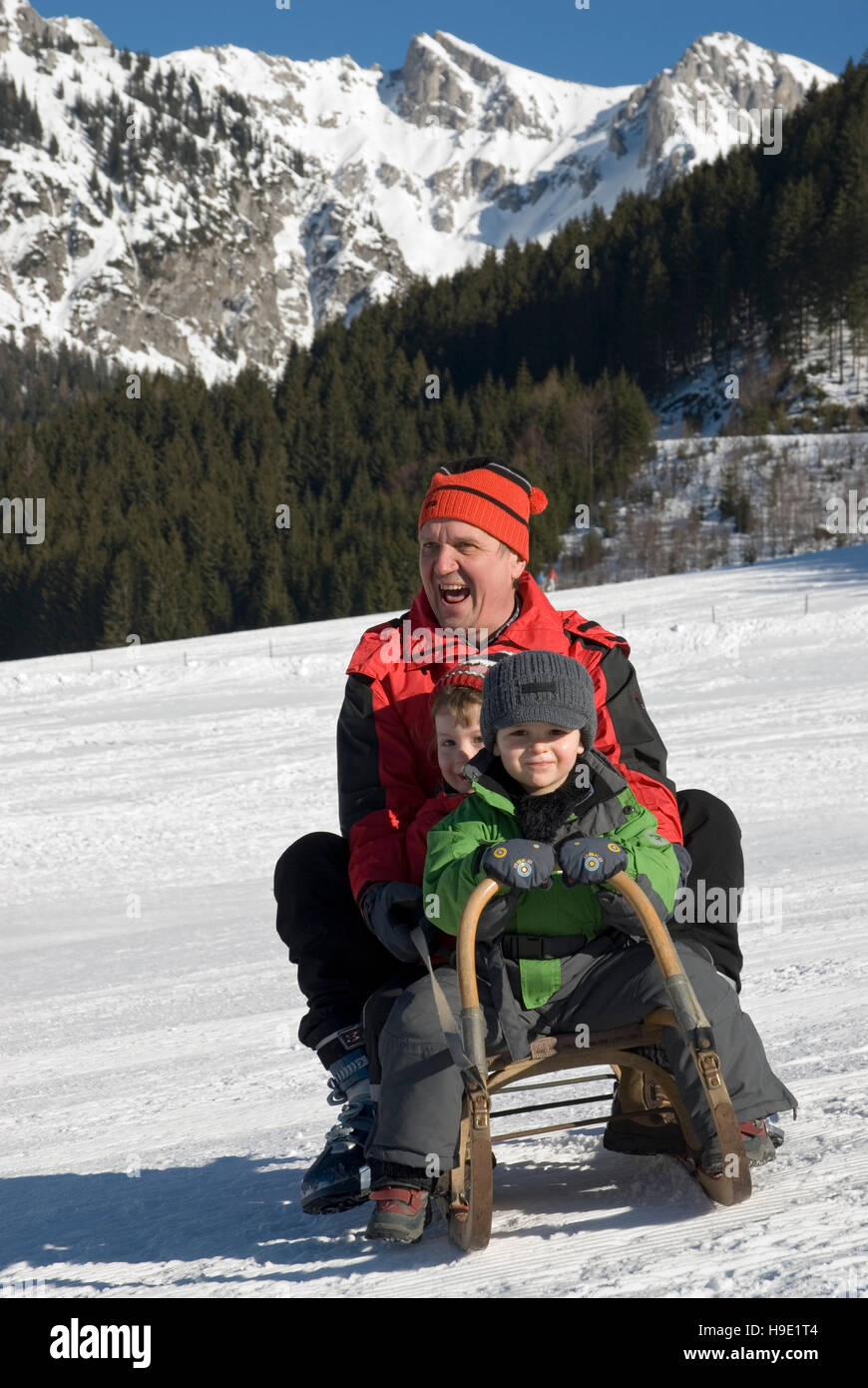 Uomo e bambini su una slitta Foto Stock