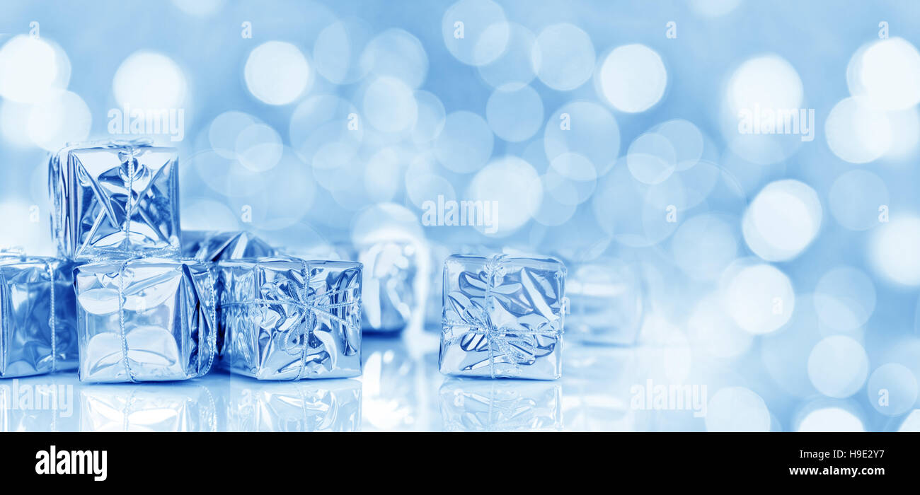Piccoli regali di Natale in carta lucida, panoramica Natale sfondo blu Foto Stock