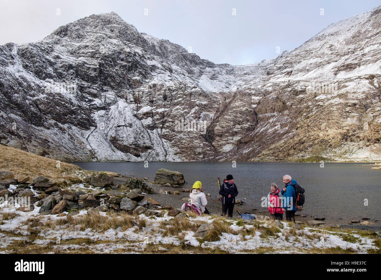 Gli escursionisti in appoggio dal lago Glaslyn sotto il monte Snowdon picco con la neve in inverno. Parco Nazionale di Snowdonia (Eryri). North Wales UK Gran Bretagna Foto Stock