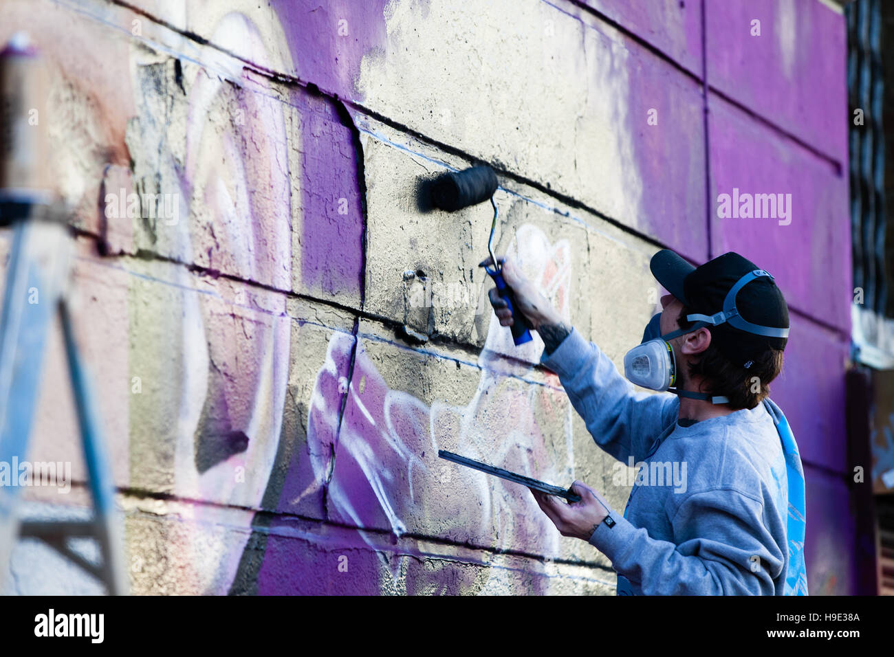 Graffiti gli artisti lavorano in Camden Market con vernici spray e di rulli creazione wall art, Londra Foto Stock