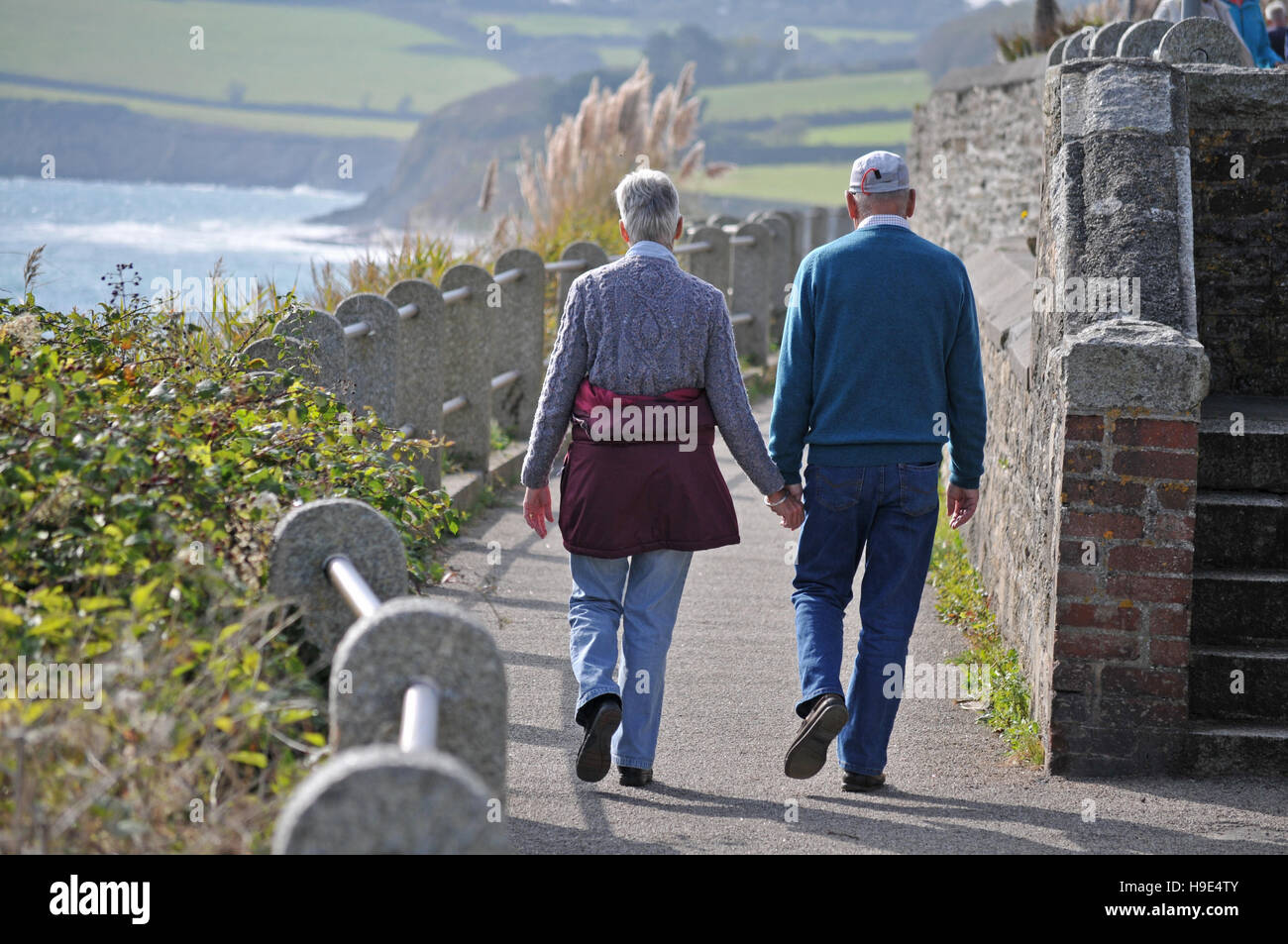 Una coppia di anziani a piedi lungo il fronte mare in Falmouth, Cornwall Foto Stock