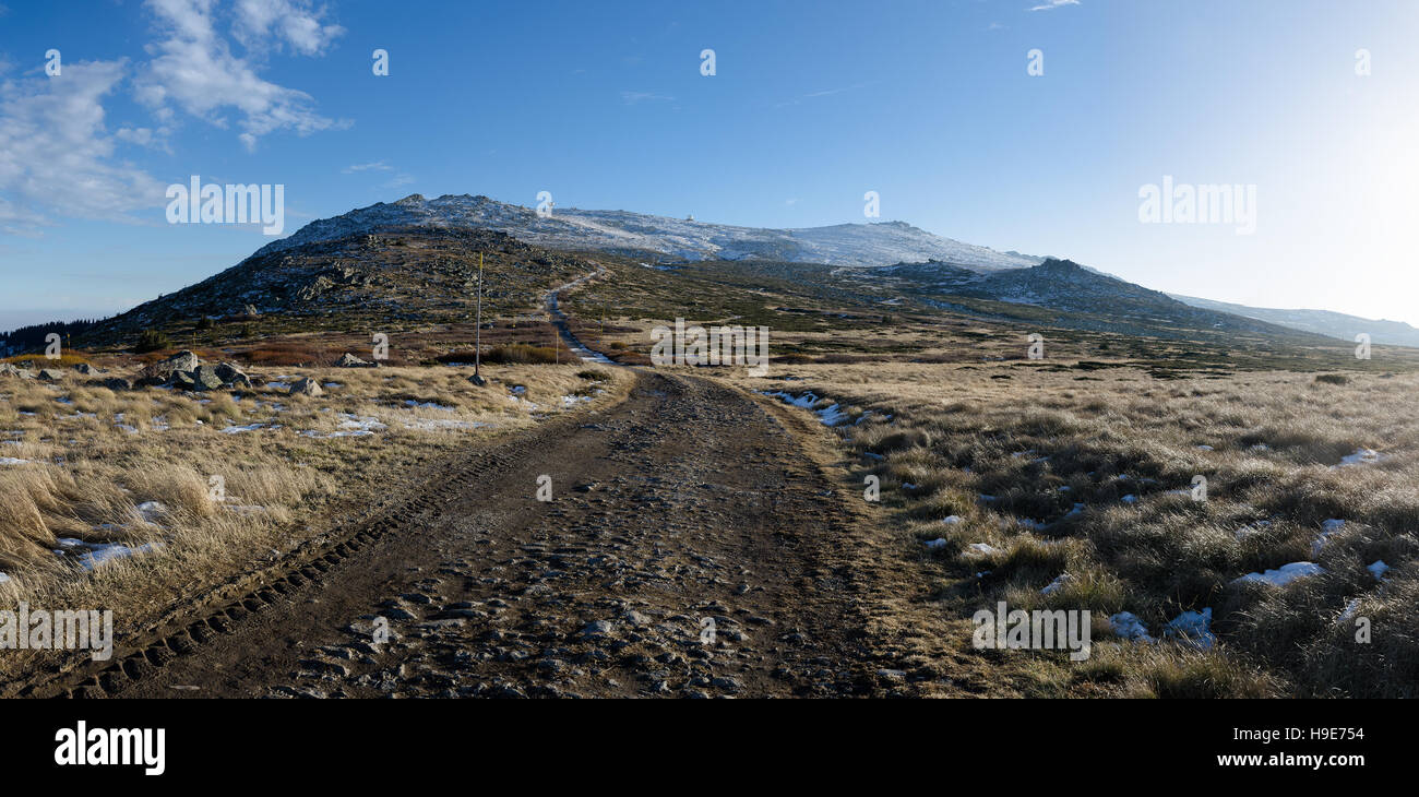 Strada con pneumatici via e coperta di neve Cherni Vruh picco in background, montagna Vitosha, Bulgaria Foto Stock