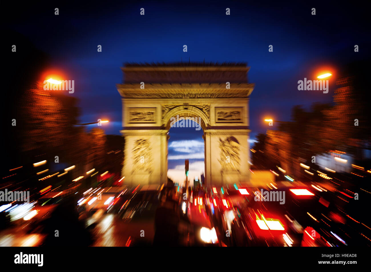Immagine con la fotocamera fatto effetto di zoom del famoso arco trionfale a Parigi di notte Foto Stock
