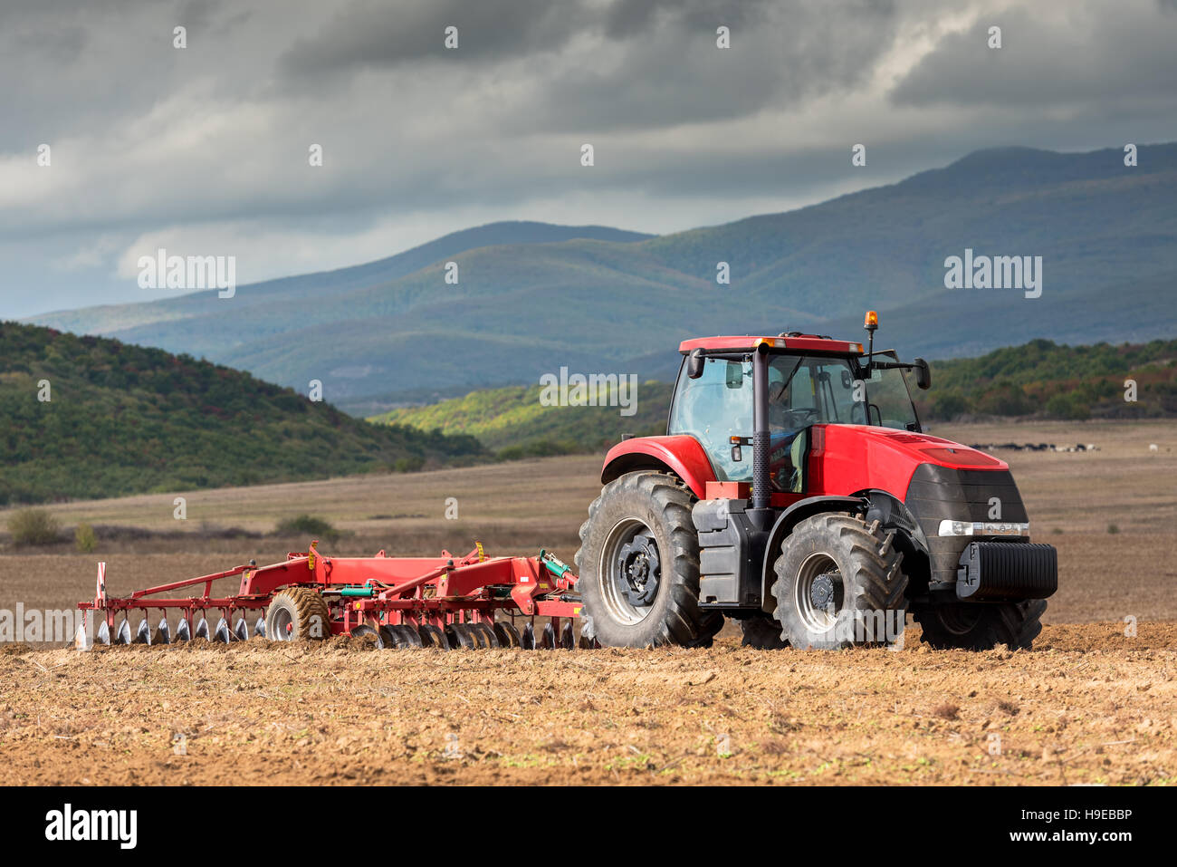 Il trattore lavora in azienda, un moderno trasporto agricolo, un agricoltore lavora nel campo. Foto Stock