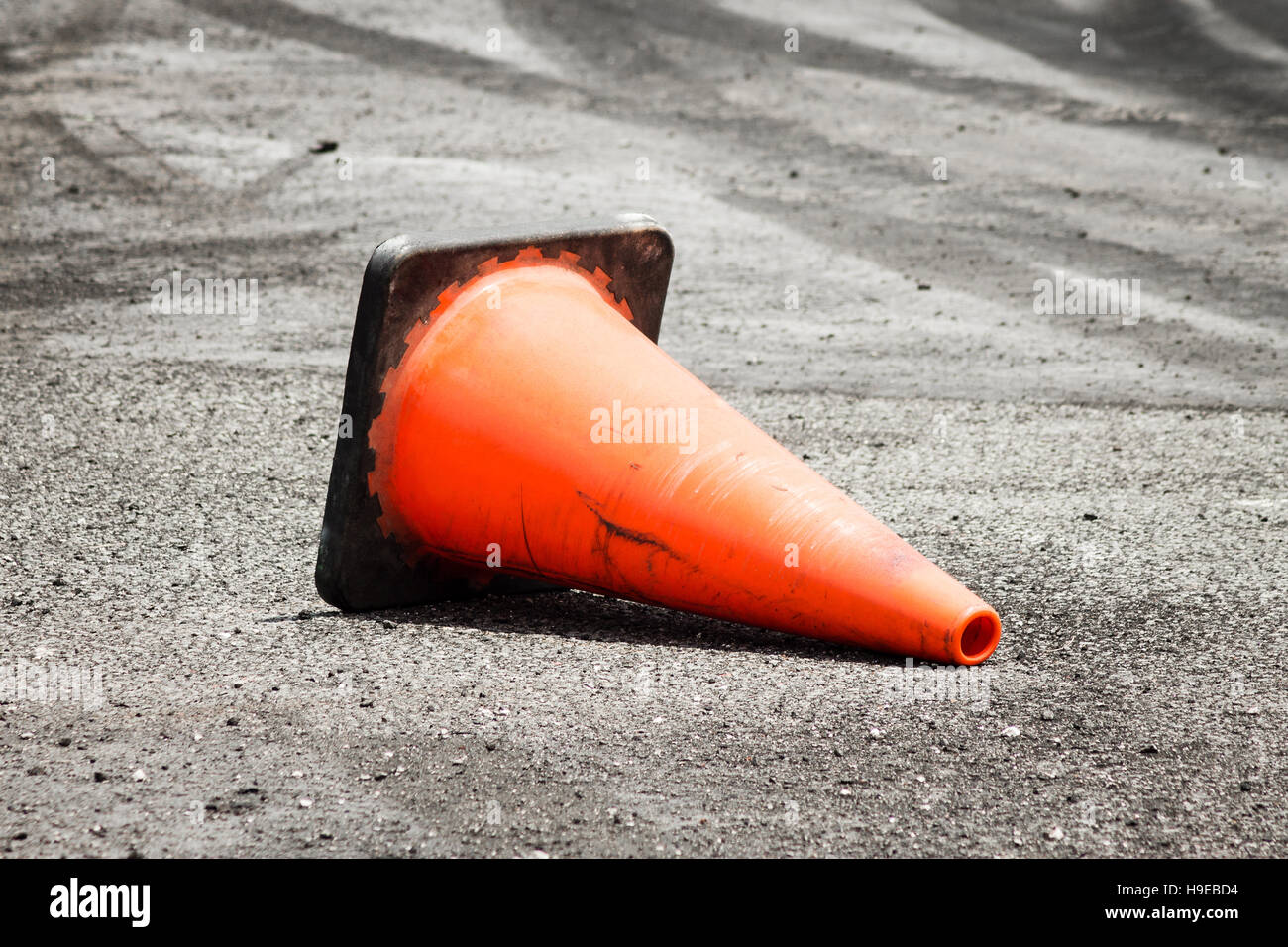 Arancione cono di traffico di cui orizzontalmente sulla strada come un cartello stradale. Foto Stock