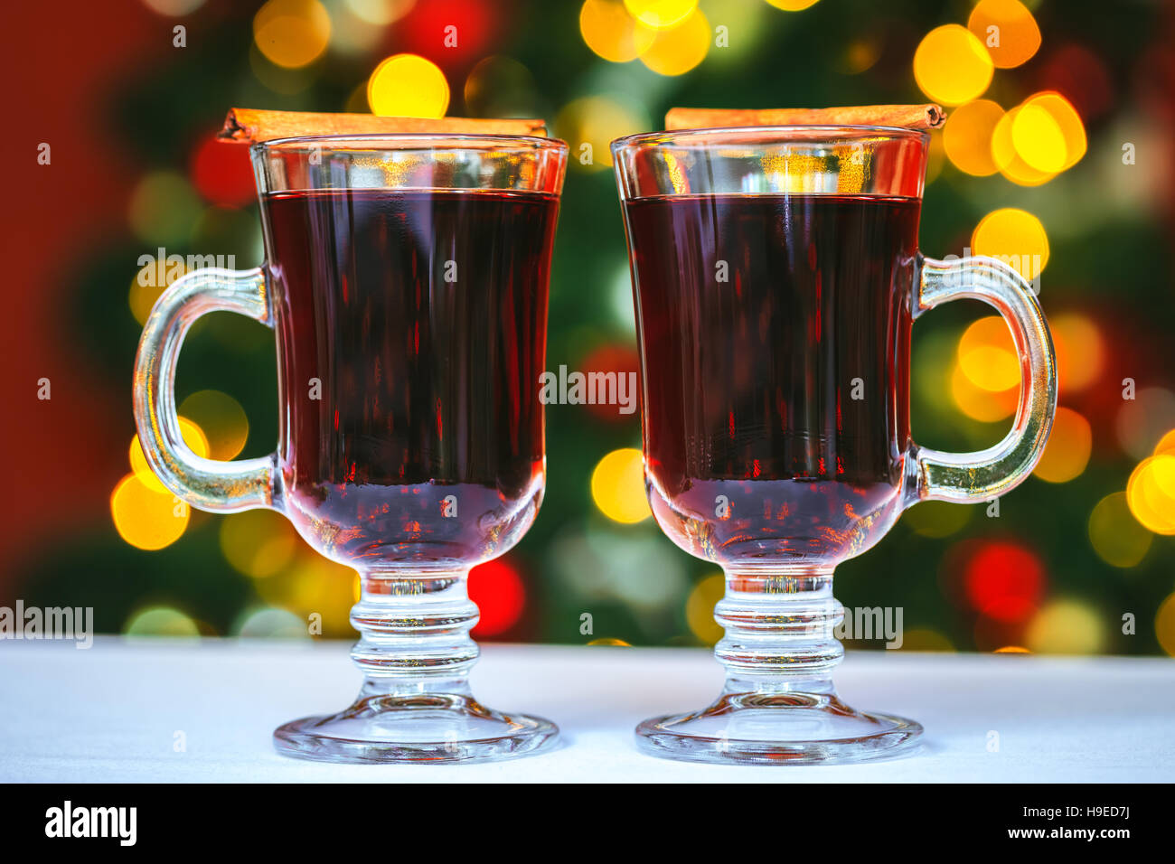 Bella due bicchieri di vino brulé su sfondo bokeh di fondo albero di Natale decorato. L'idea per cartoline. soft focus. shallow dof Foto Stock