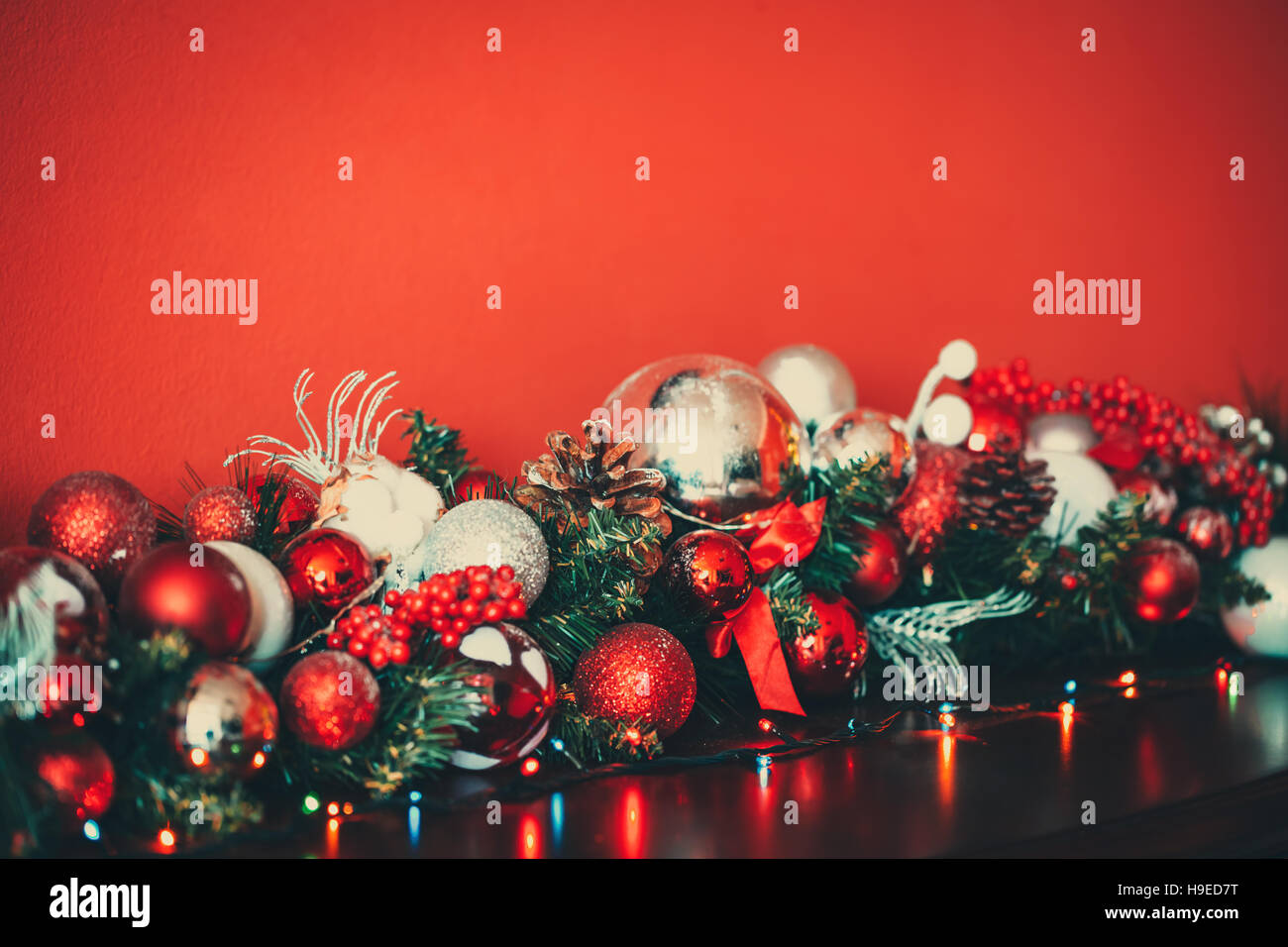 Natale ghirlanda decorativa con rami di abete rosso e argento baubles, pigne e altri ornamenti, nel nuovo anno di sfondo Foto Stock
