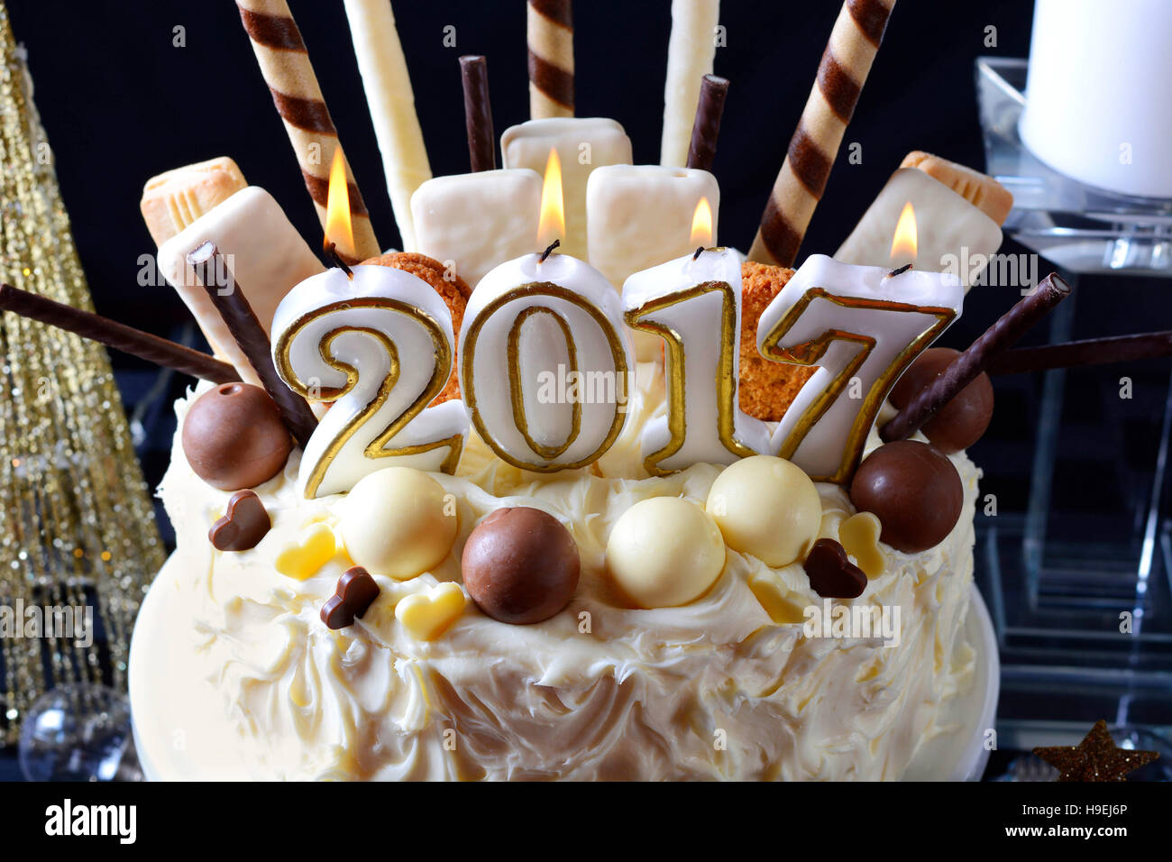 Periodo festivo 2017 Felice Anno Nuovo impediva di procedere centrotavola bianco torta al cioccolato con caramelle e biscotti decorazioni contro uno sfondo nero. Foto Stock