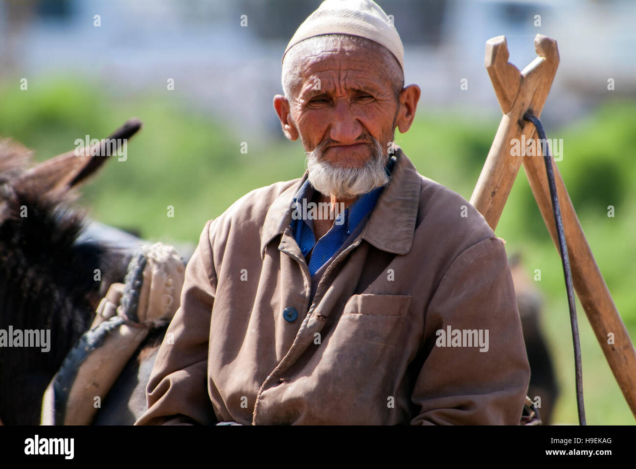 Un etnica Uighur uomo alla domenica mercato del bestiame a Kashgar nella provincia dello Xinjiang in Cina. Foto Stock