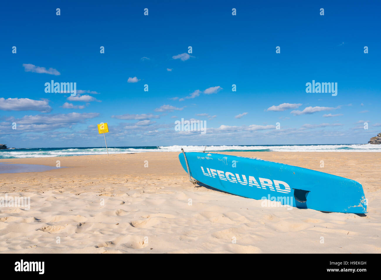 Bagnino di salvataggio con la tavola da surf in spiaggia Foto Stock