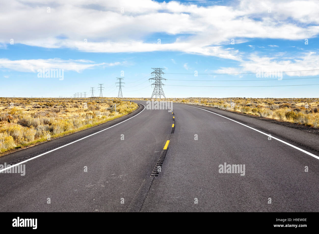 Un vuoto autostrada rurale con poli elettrici. Foto Stock