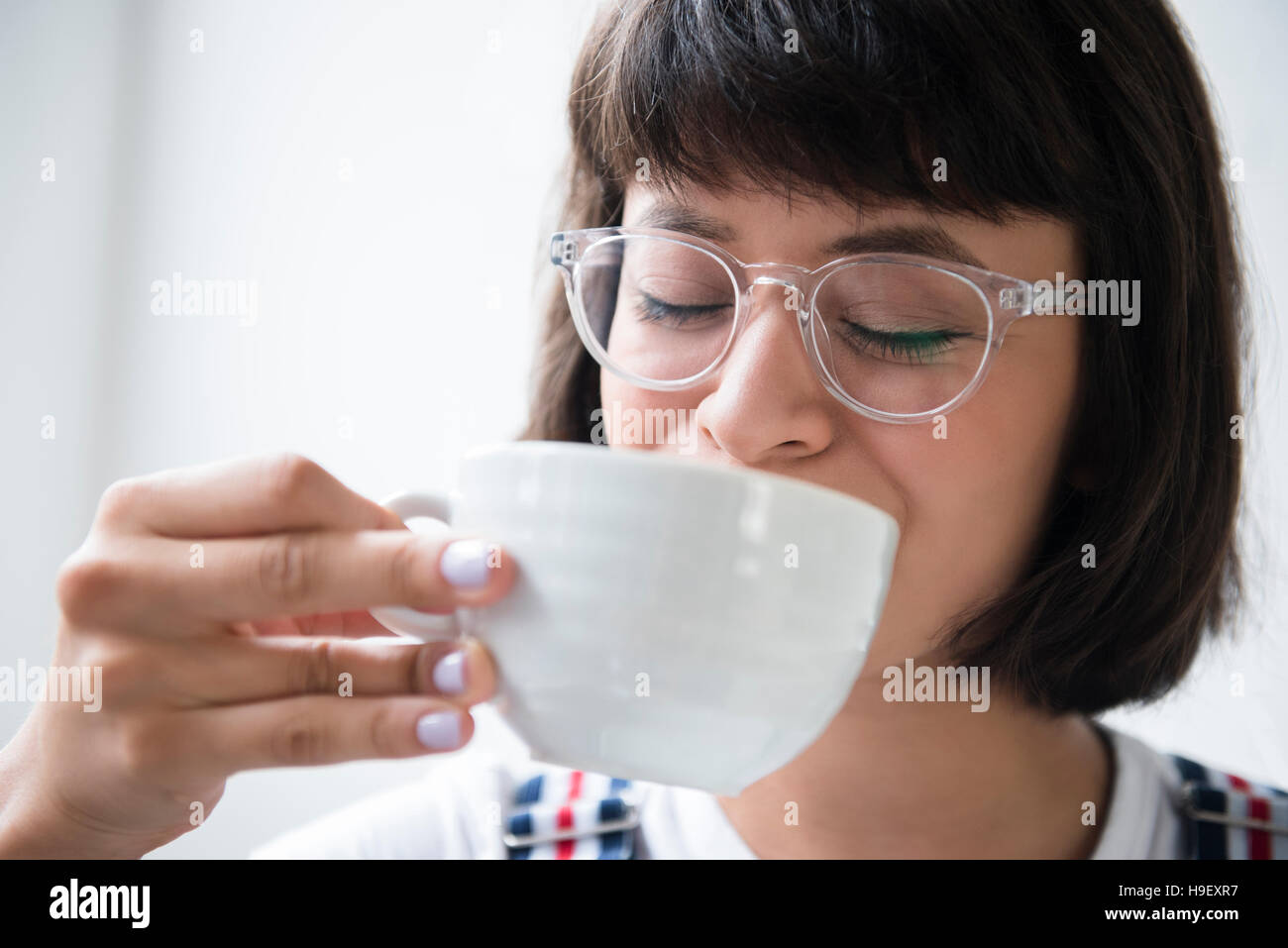 Donna ispanica di bere il caffè Foto Stock