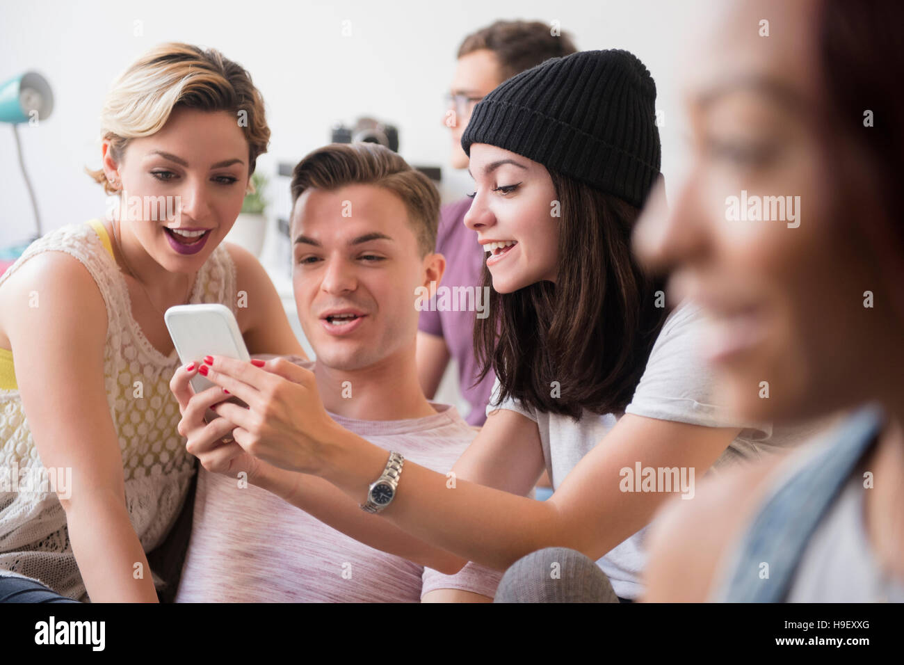 Sorridente amici sms sul cellulare Foto Stock