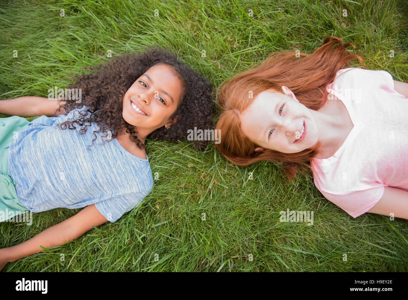 Ritratto di ragazze sorridenti che stabilisce in erba Foto Stock
