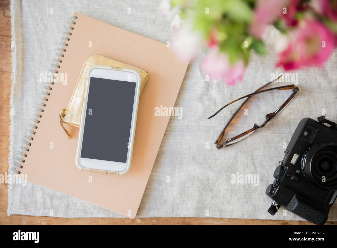 Fotocamera, telefono cellulare, portamonete, notebook e portafoglio sul tavolo Foto Stock