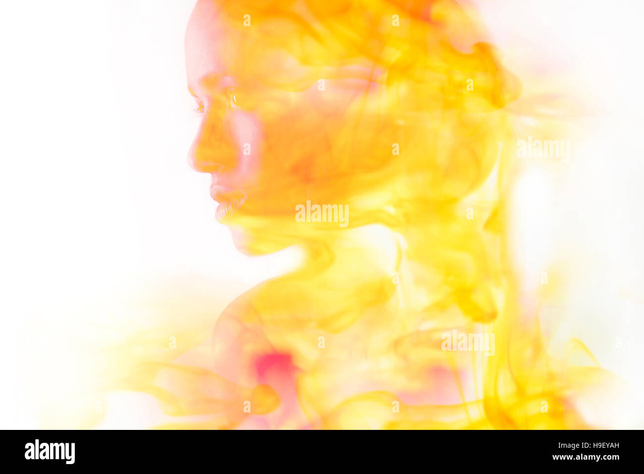 Doppia esposizione della faccia di razza mista donna e fuoco Foto Stock