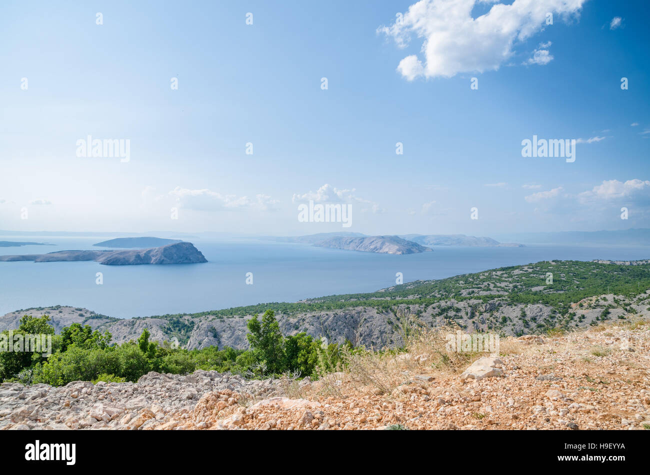 Costa della Croazia in una bella giornata di sole che si affaccia su isole rocciose dalla riva verde Foto Stock