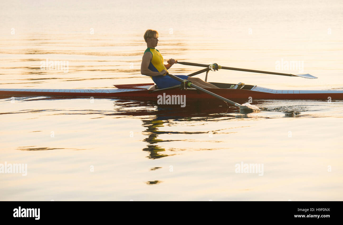 Uomo caucasico canottaggio sul lago Foto Stock