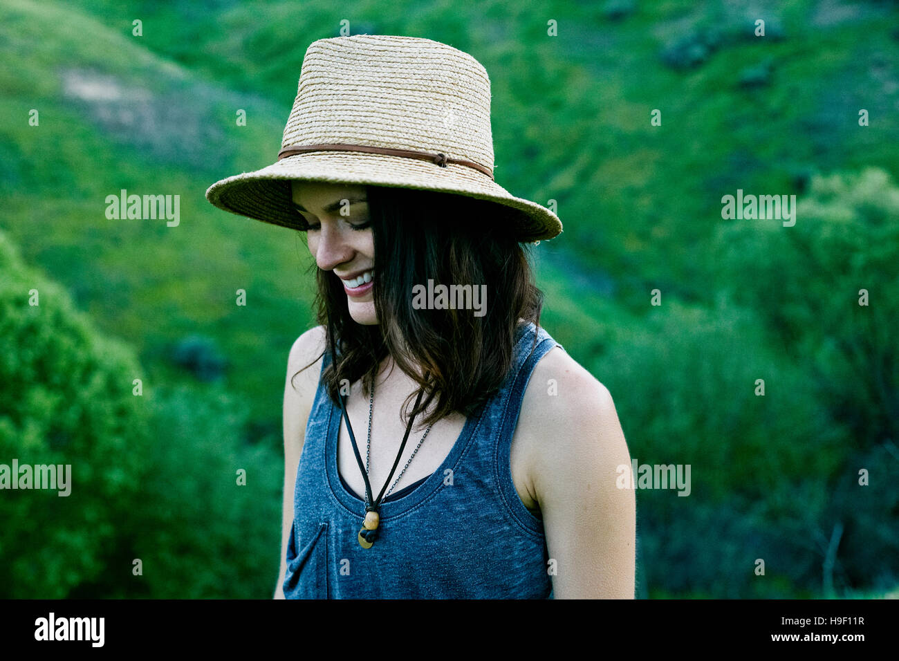 Donna sorridente indossando hat sulla collina Foto Stock