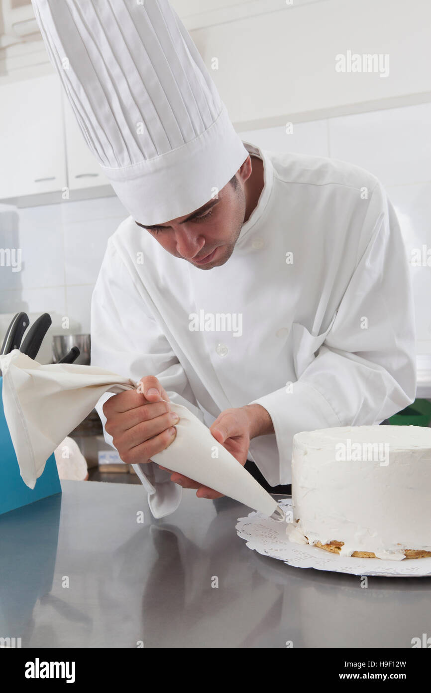 Lo chef ispanica decorare la torta Foto Stock