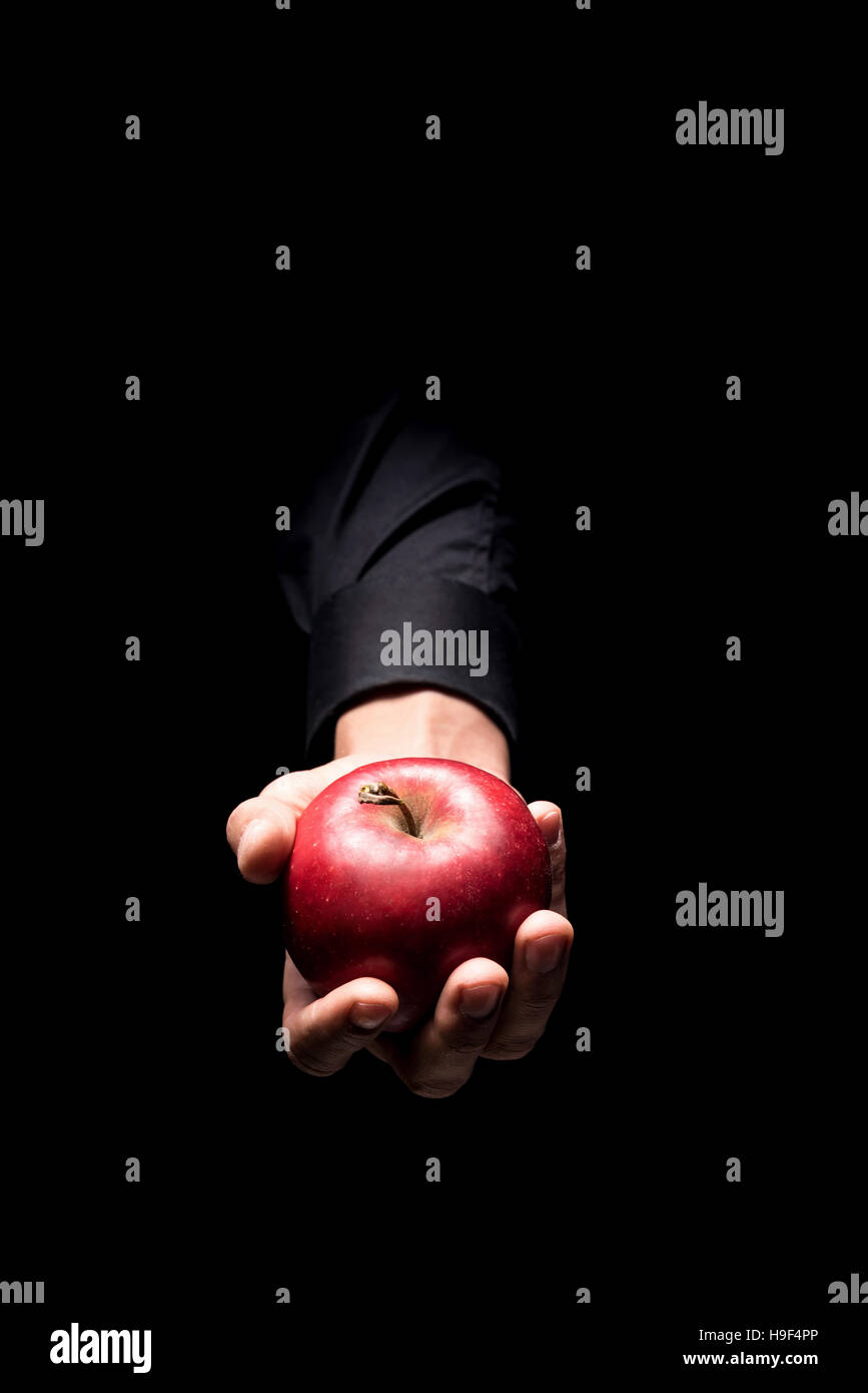 Close up del mans mano che tiene una mela rossa Foto Stock