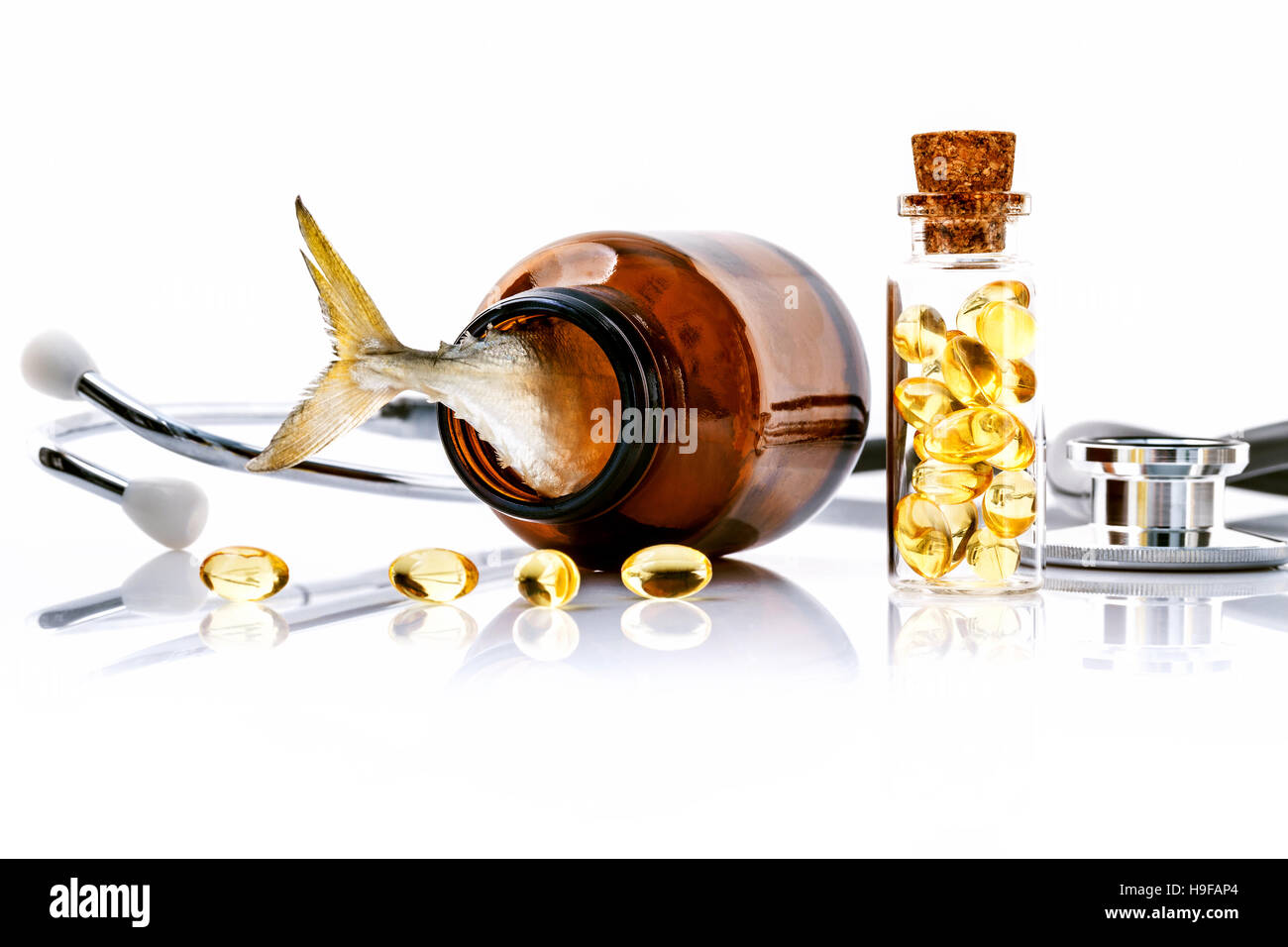 Olio di fegato di pesce di capsule in bottiglia con uno stetoscopio isolare su wh Foto Stock