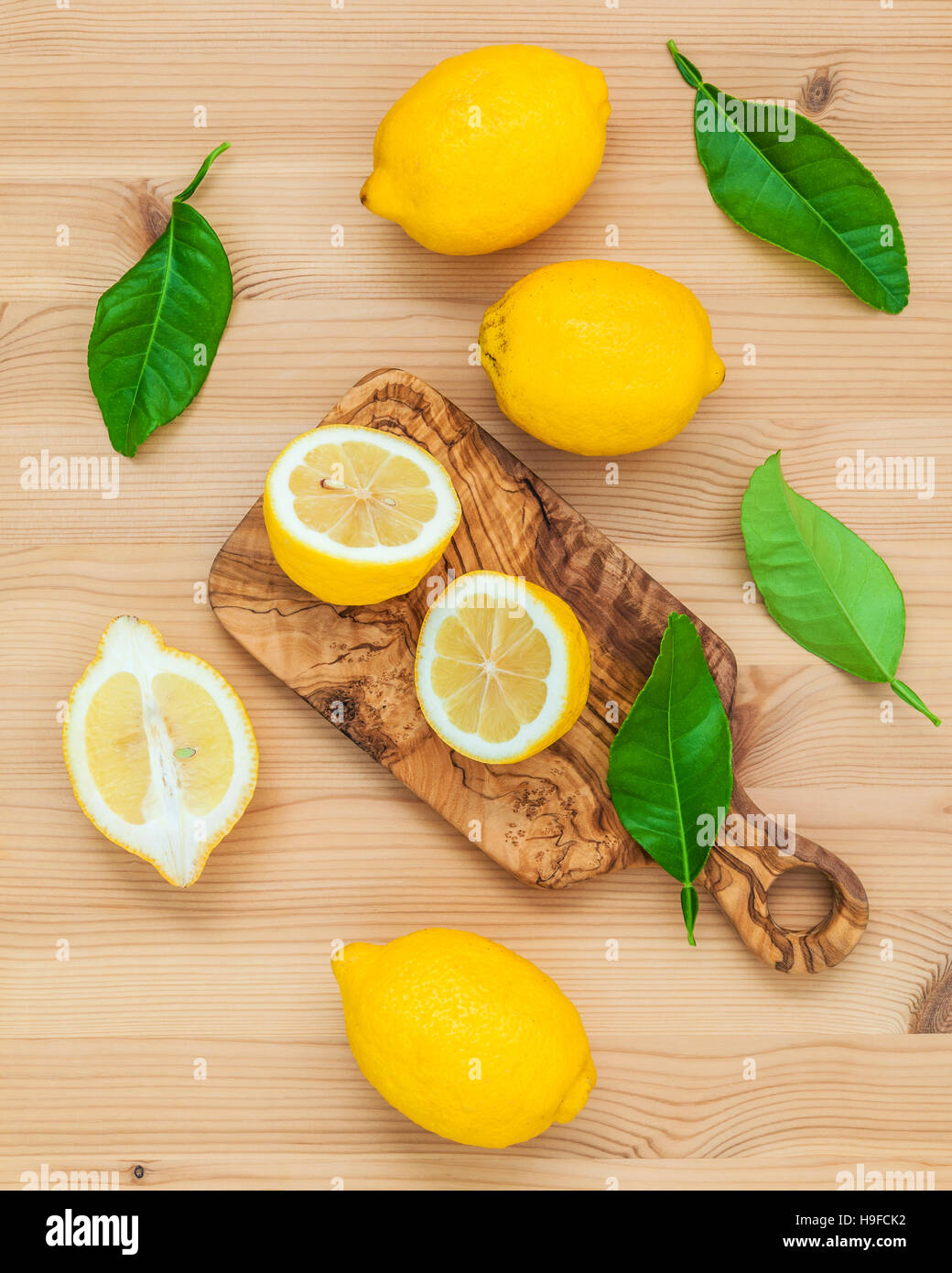 Limoni freschi Limoni e foglie sul legno rustico sfondo. Fre Foto Stock