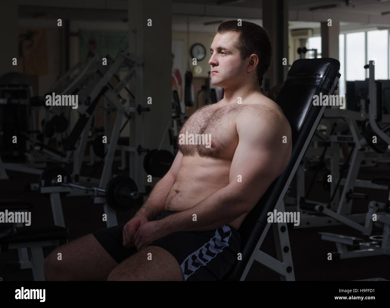 Giovane uomo muscolare riposo dopo esercizio in palestra Foto Stock