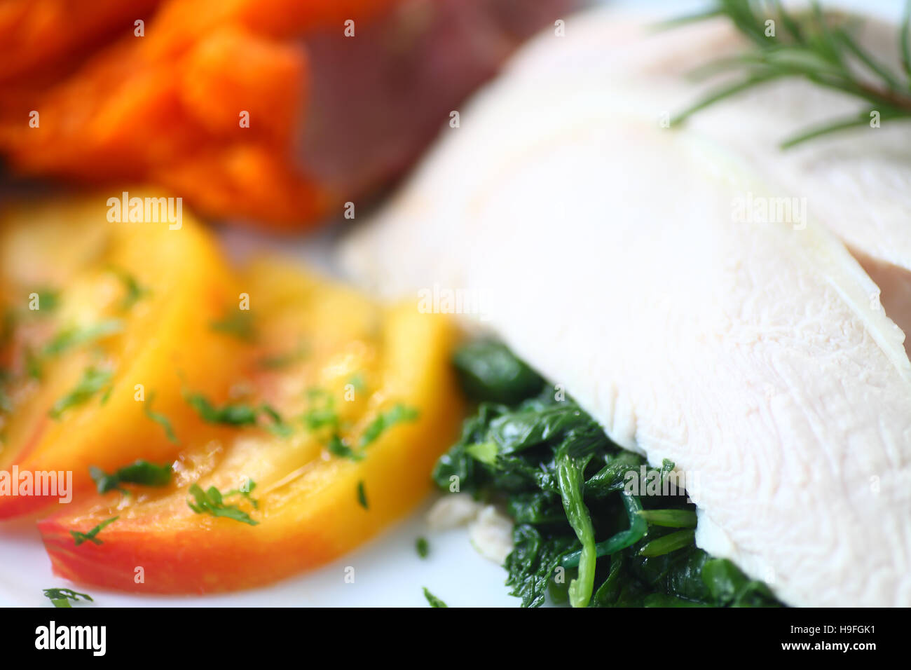 In camicia le fette di pollo su saltata di baby kale con dolce di patata e di pomodoro Foto Stock