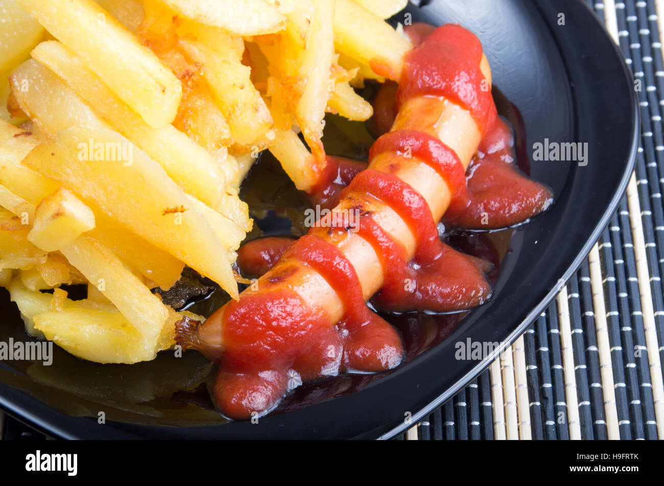 Il russo piatto nazionale - salsicce fritte con ketchup e un contorno di patate fritte closeup Foto Stock