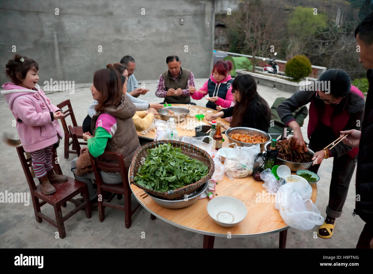 Un gruppo di amici fare gnocchi di fresco per cena durante una fattoria-soggiorno vacanza nelle montagne della Cina occidentale. Foto Stock
